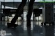 A woman walking with her legs crossed in an airport.