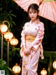 A woman in a kimono holding an umbrella in the rain.