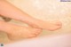 A woman's feet in a bathtub filled with water.