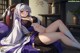 Anime girl in a purple and white outfit laying on a bed.