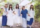 A group of young women walking down a path holding hands.