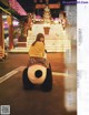 A woman sitting on top of a giant stuffed panda bear.