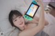 A woman laying on a bed holding a Nintendo Switch.