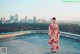 A woman in a kimono standing on top of a building.