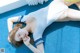 A woman in a white bathing suit laying on a blue carpet.