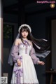 A woman in a white dress with a purple veil.